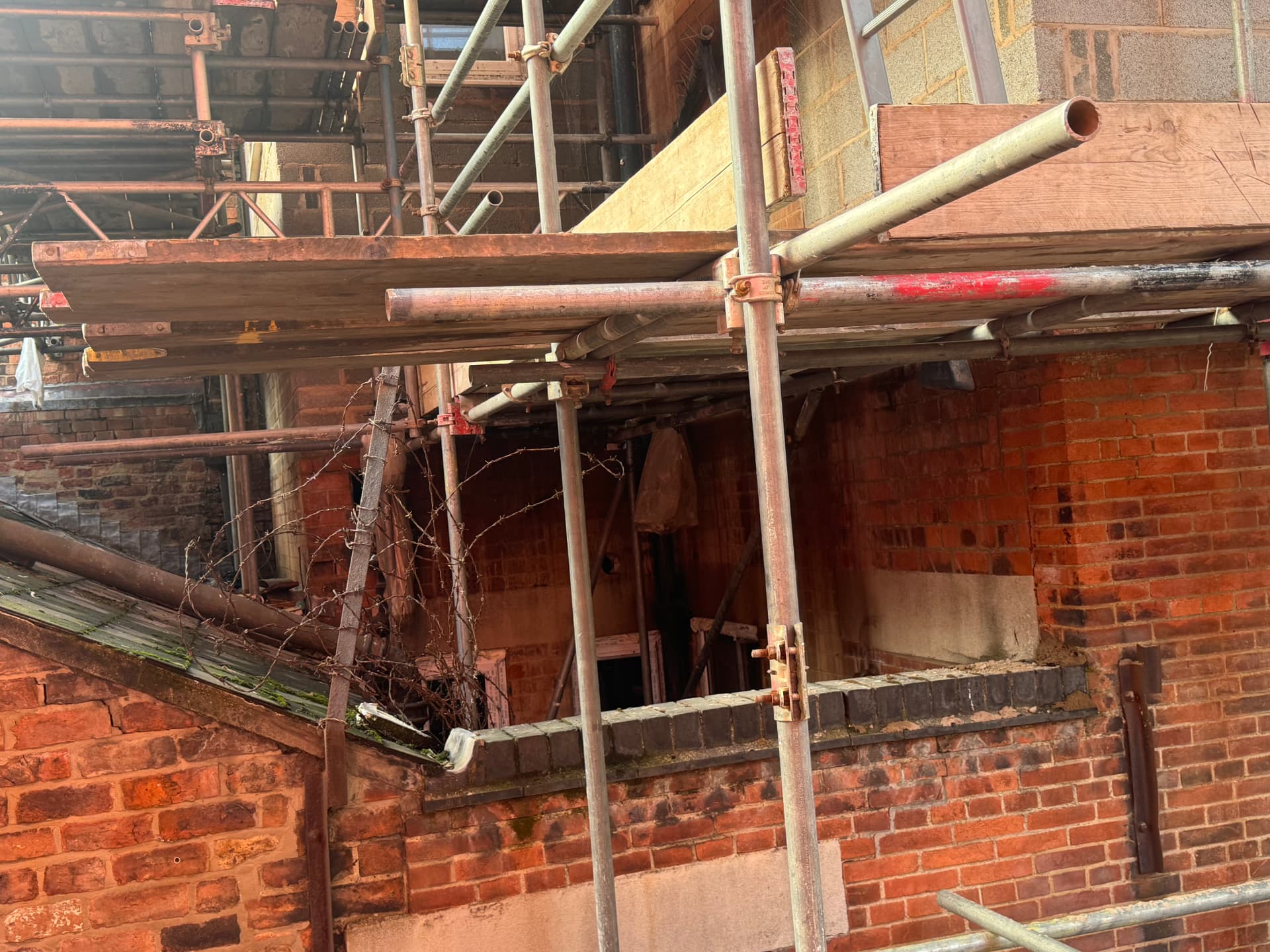 Scaffolding lifts encroaching above the adjoining owner's flat roof and brickwork