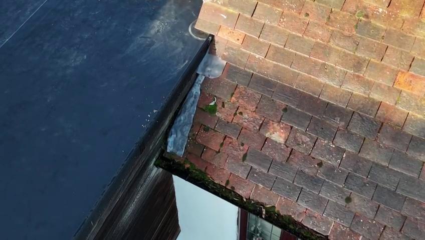 Damage recorded where the new flat roof meets the historic clay tiled roof