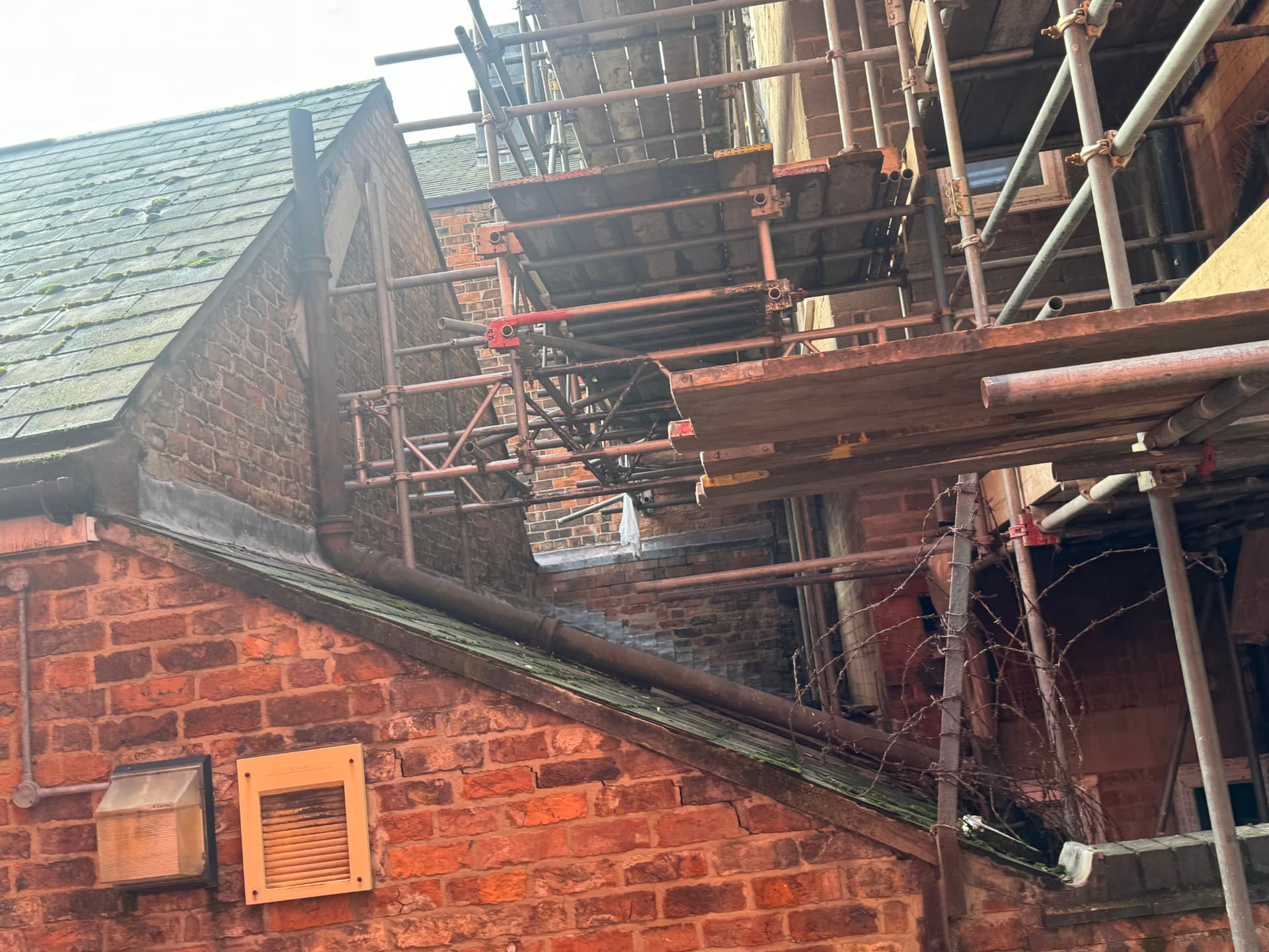 Scaffolding erected over the boundary alongside a neighbouring pitched roof